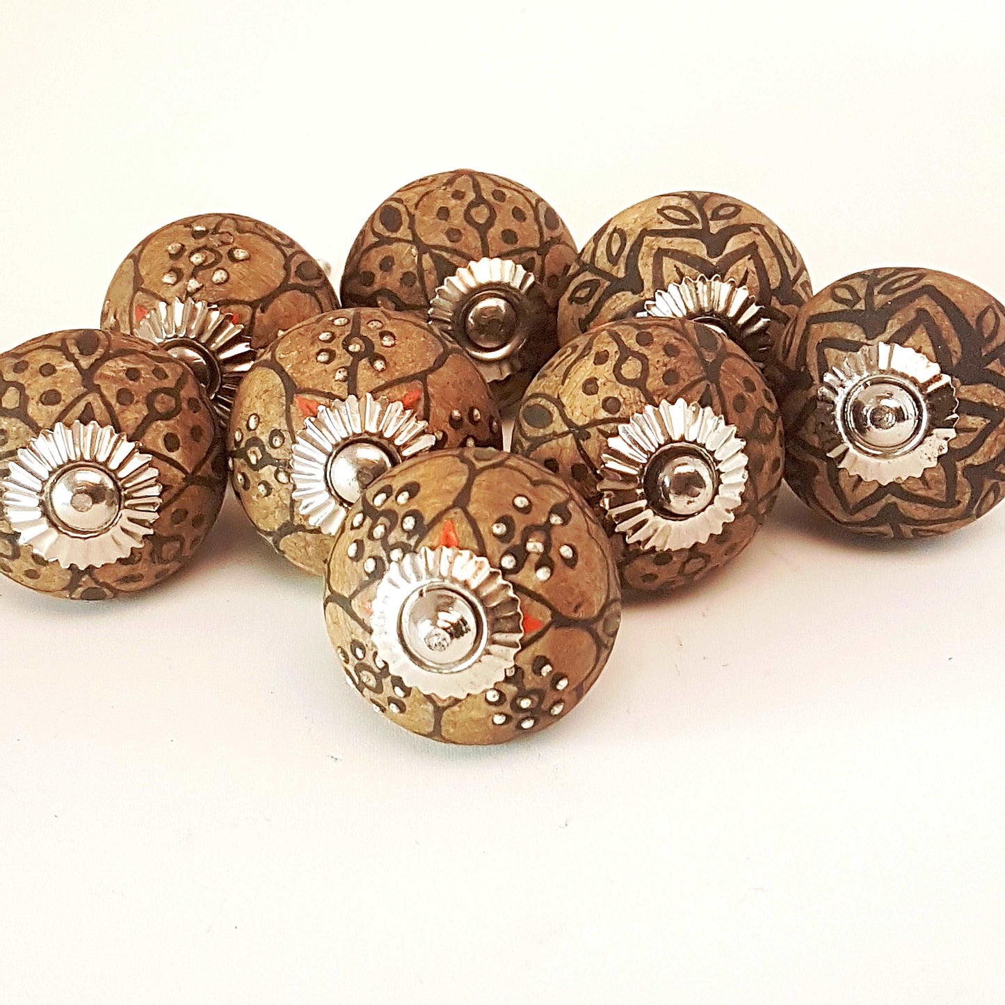 8 cabinet knobs hand painted in rustic country designs. Black & brown floral patterns with silver hardware. Easy and affordable DIY decor.