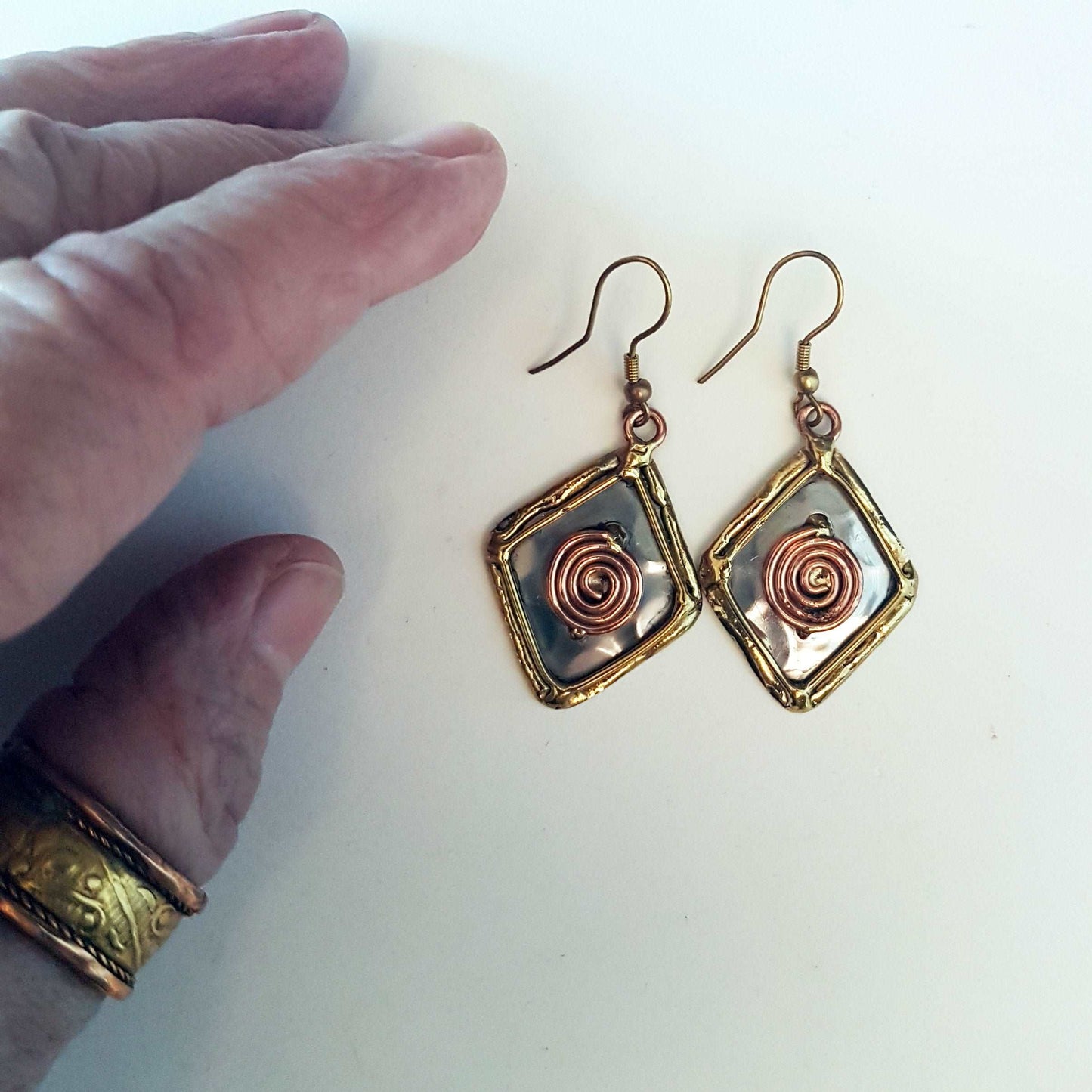 Celtic silver earrings in a diamond shape with gold and copper tone wirework detail.