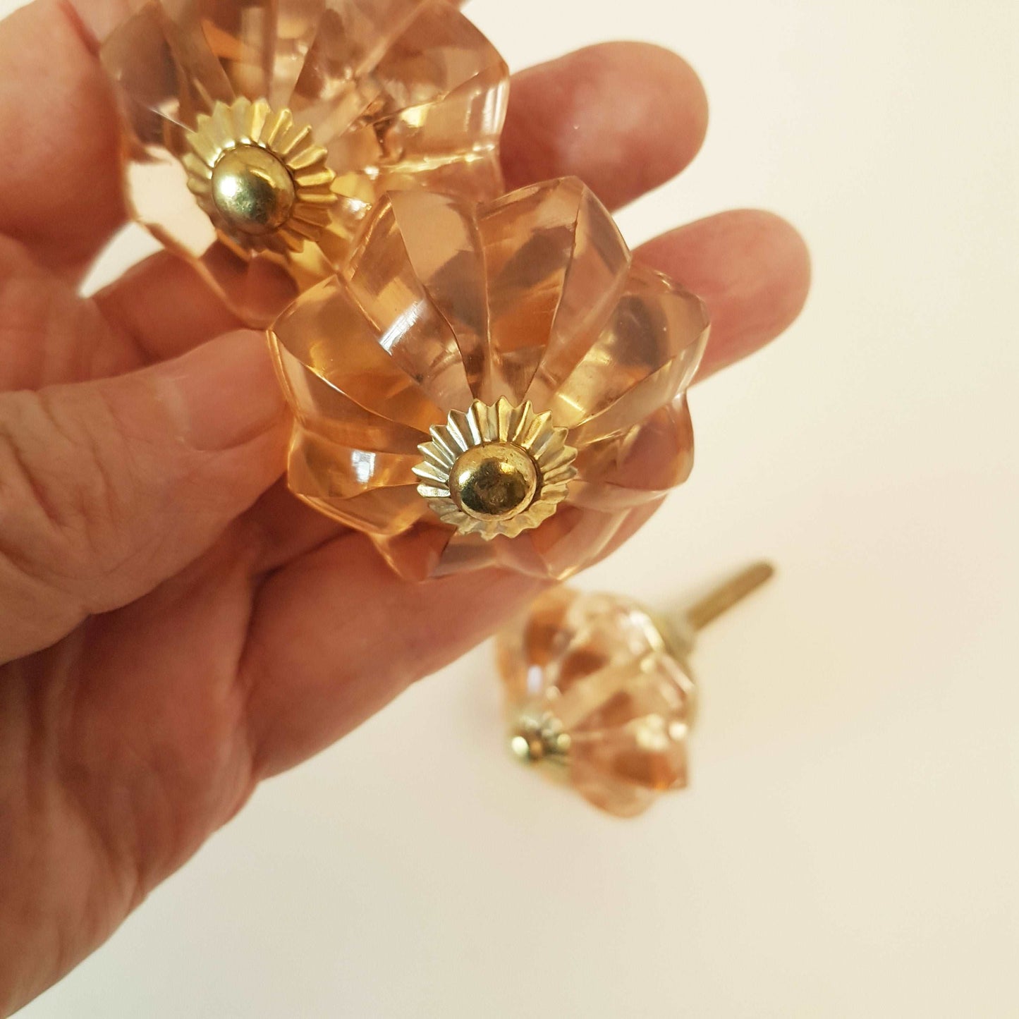 8 cranberry glass cabinet knobs with gold tone accents. Pink crystal look cut glass drawer pulls. For kitchen cupboards, dressers, vanities.