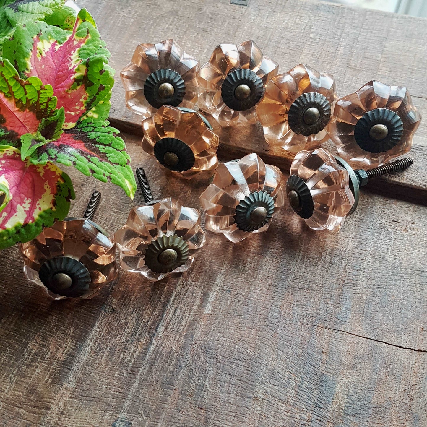 8 cranberry glass cabinet knobs with antique finish bronze centers. Transparent pink cut glass drawer pulls. Furniture hardware. 1.5 inch.