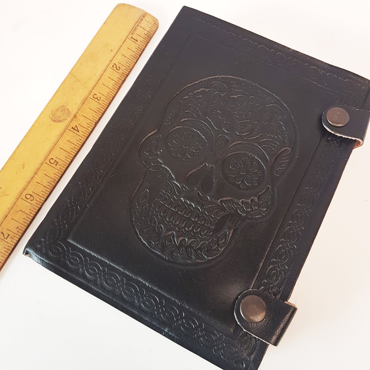 Genuine black leather bound sugarskull design journal. Black 5x7 inch skull grimoire with blank premium quality paper pages.