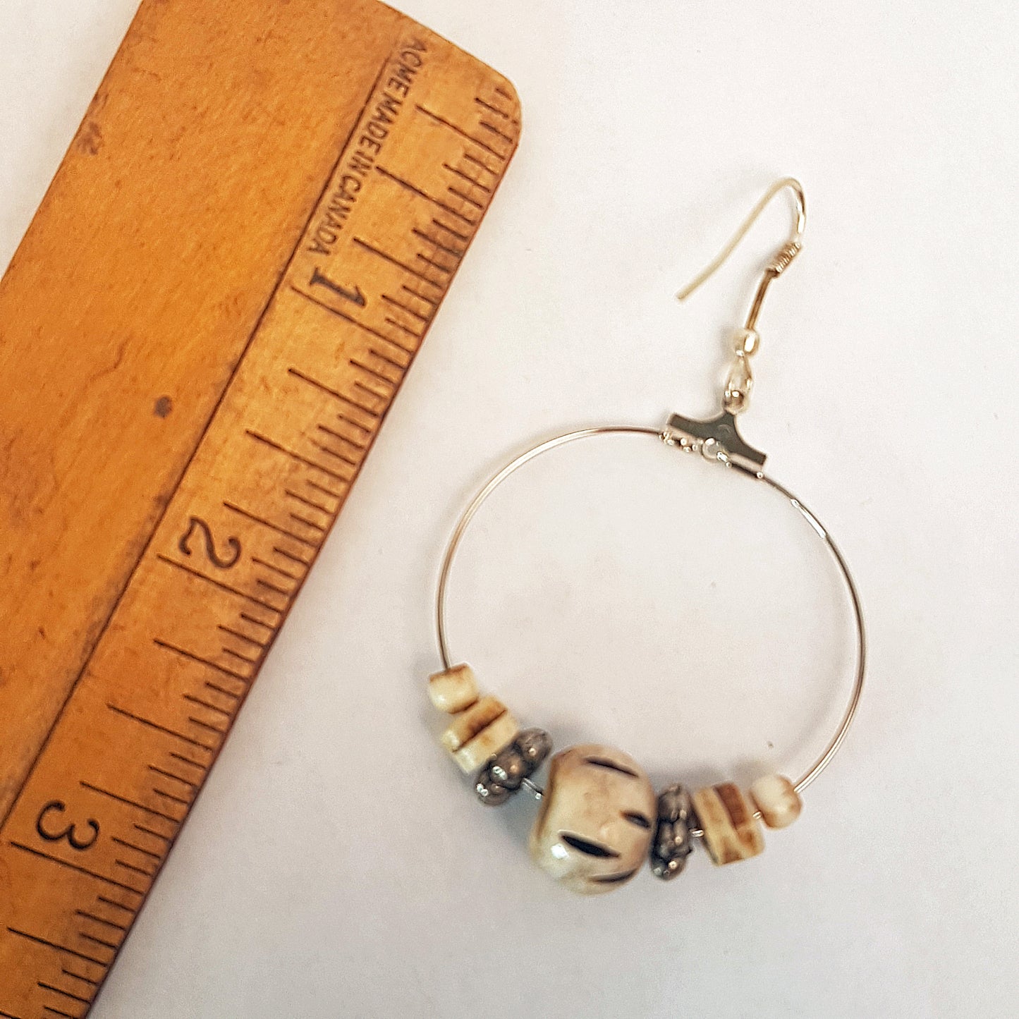 Silver hoop earrings with silver & carved bone beads. 2.5 inches hang length.