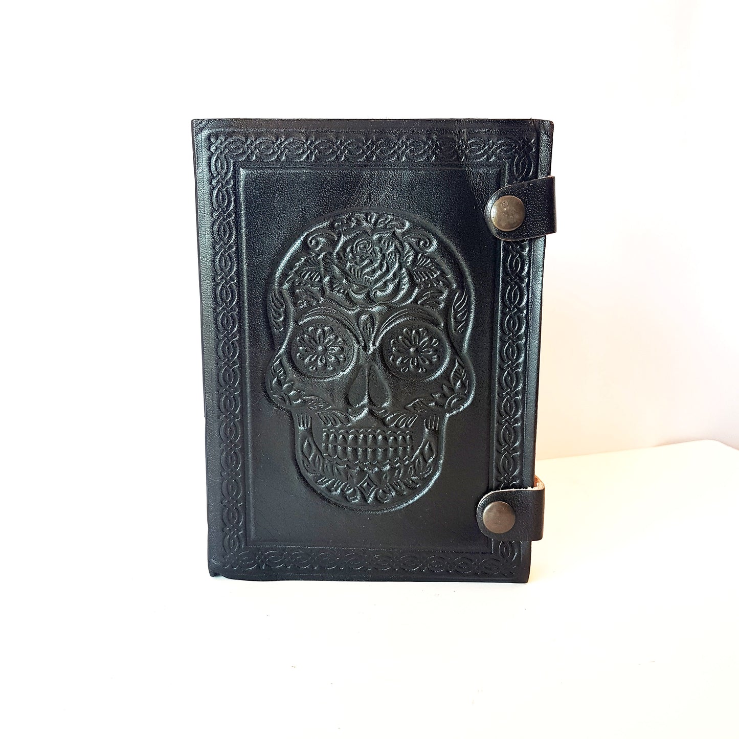 Genuine black leather bound sugarskull design journal. Black 5x7 inch skull grimoire with blank premium quality paper pages.