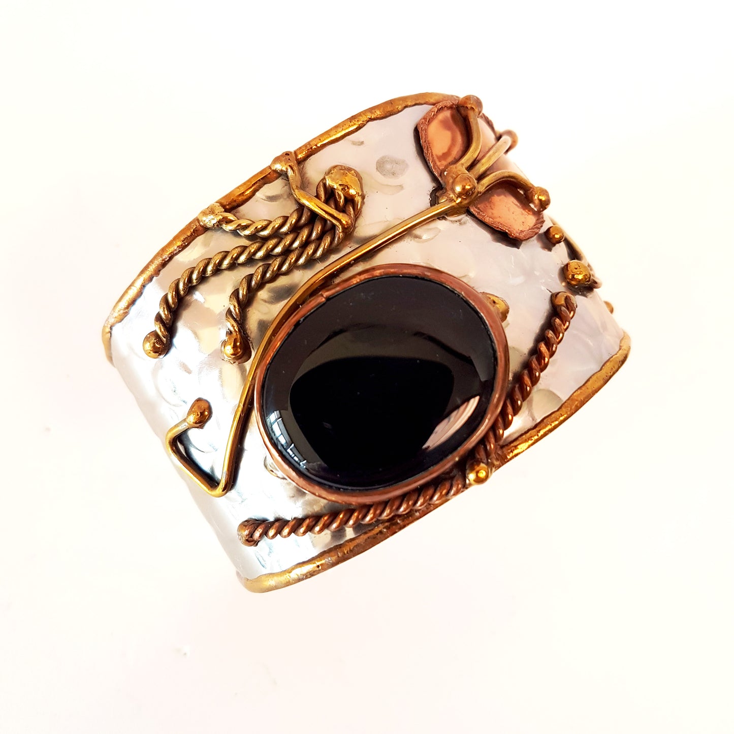 Silver cuff bracelet with a large oval shaped black onyx stone. Unique mixed metal design with copper, brass and silver. Flexible adjustable size.