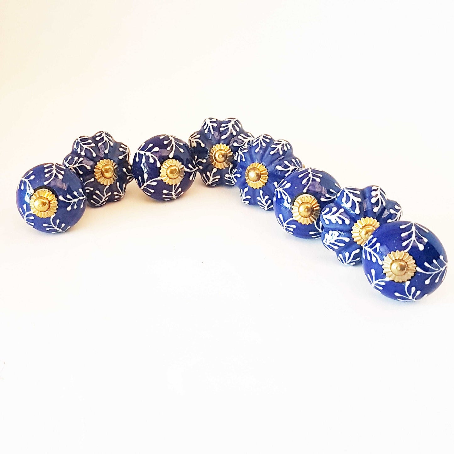 8 Delft cabinet knob drawer pulls in cobalt blue & white hand painted embossed designs. Exclusive Regal Gold 8 piece decorator collection.