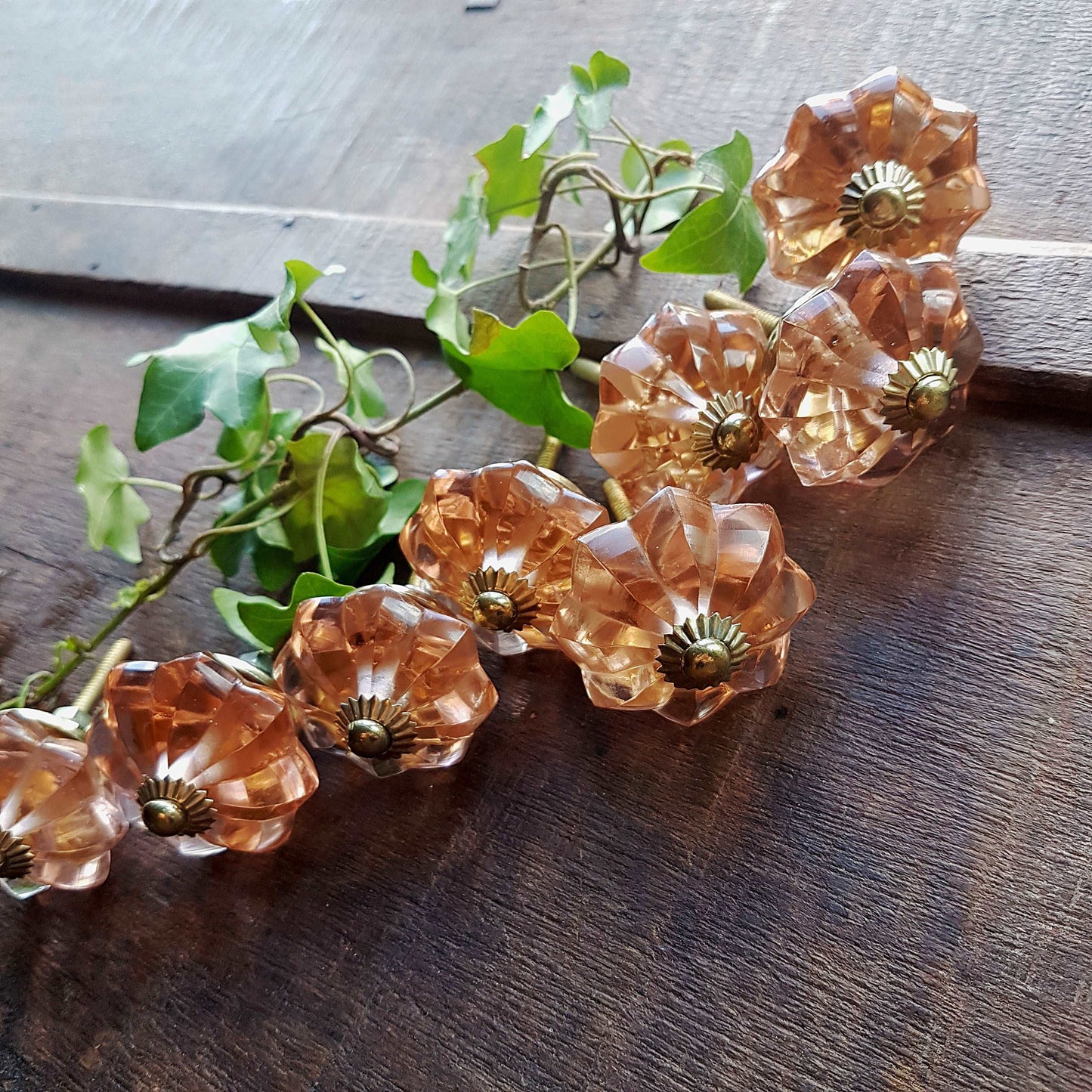 8 cranberry glass cabinet knobs with gold tone accents. Pink crystal look cut glass drawer pulls. For kitchen cupboards, dressers, vanities.