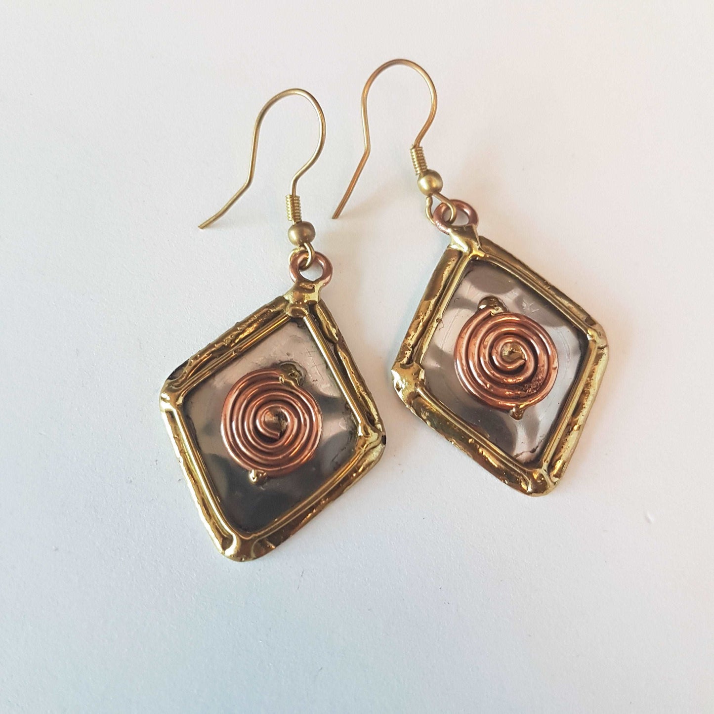 Celtic silver earrings in a diamond shape with gold and copper tone wirework detail.