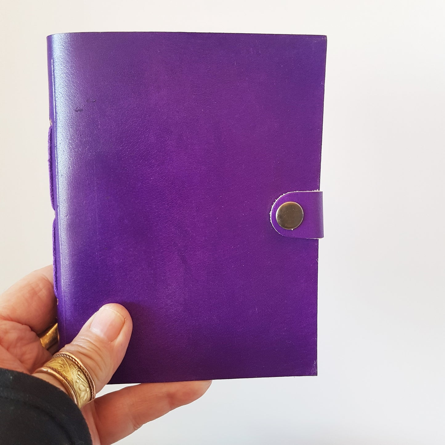 Leather bound lined journal with handmade artisan paper pages. Compact size 4.5 by 6 inches. Black, brown, red, turquoise, purple & blue.