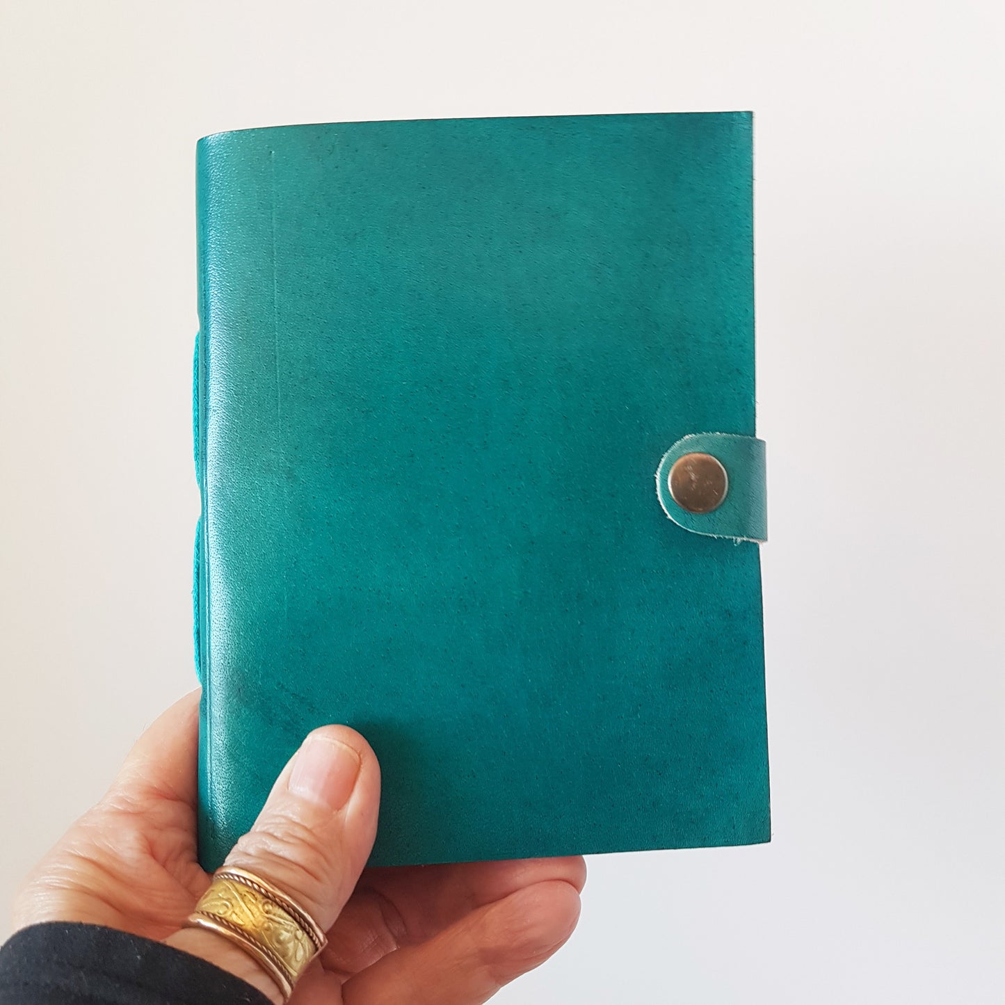Leather bound lined journal with handmade artisan paper pages. Compact size 4.5 by 6 inches. Black, brown, red, turquoise, purple & blue.