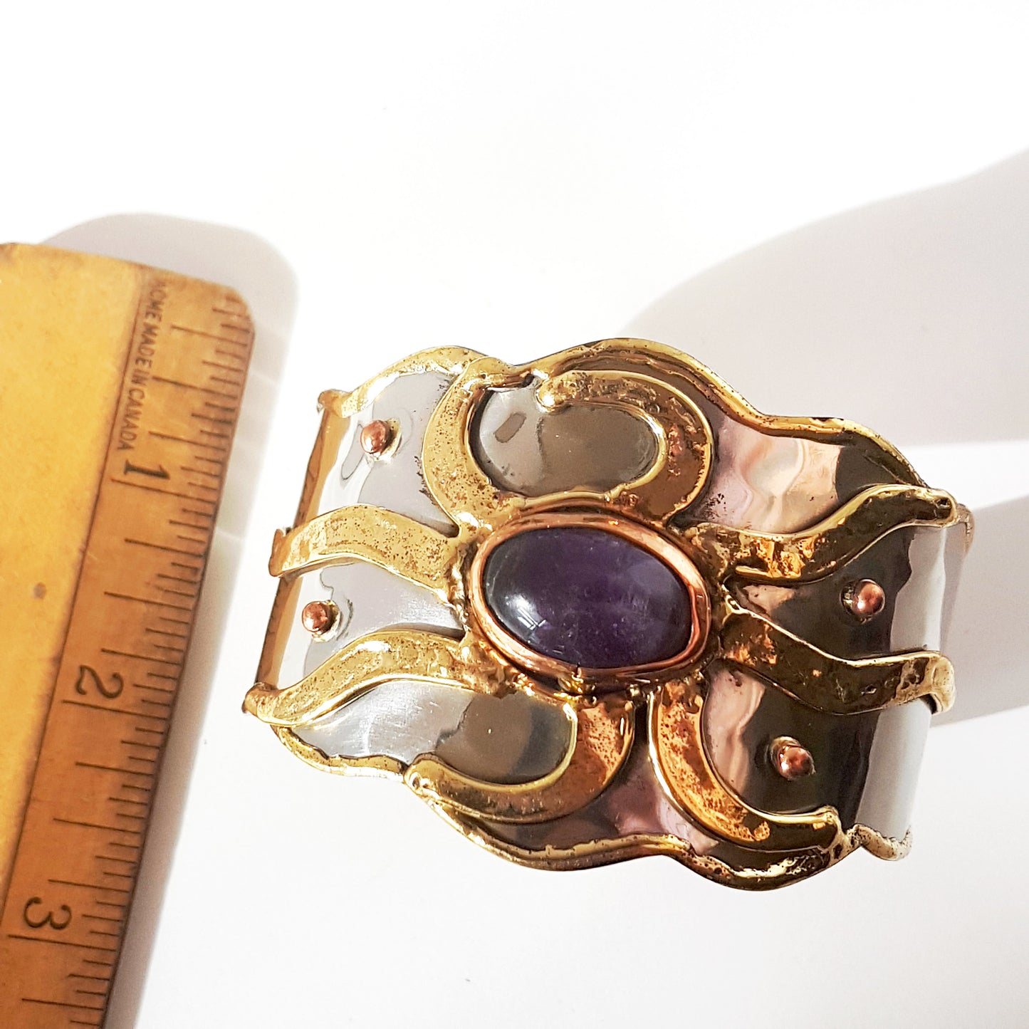 Silver cuff bracelet with inlaid gemstone center. Medieval Celtic sunrise design with brass detail. Vintage handwrought artisan metalwork.