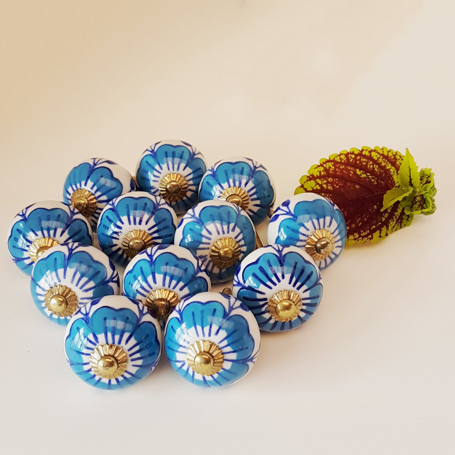 Ensemble de 12 boutons d'armoire à fleurs bleues et blanches avec quincaillerie dorée.