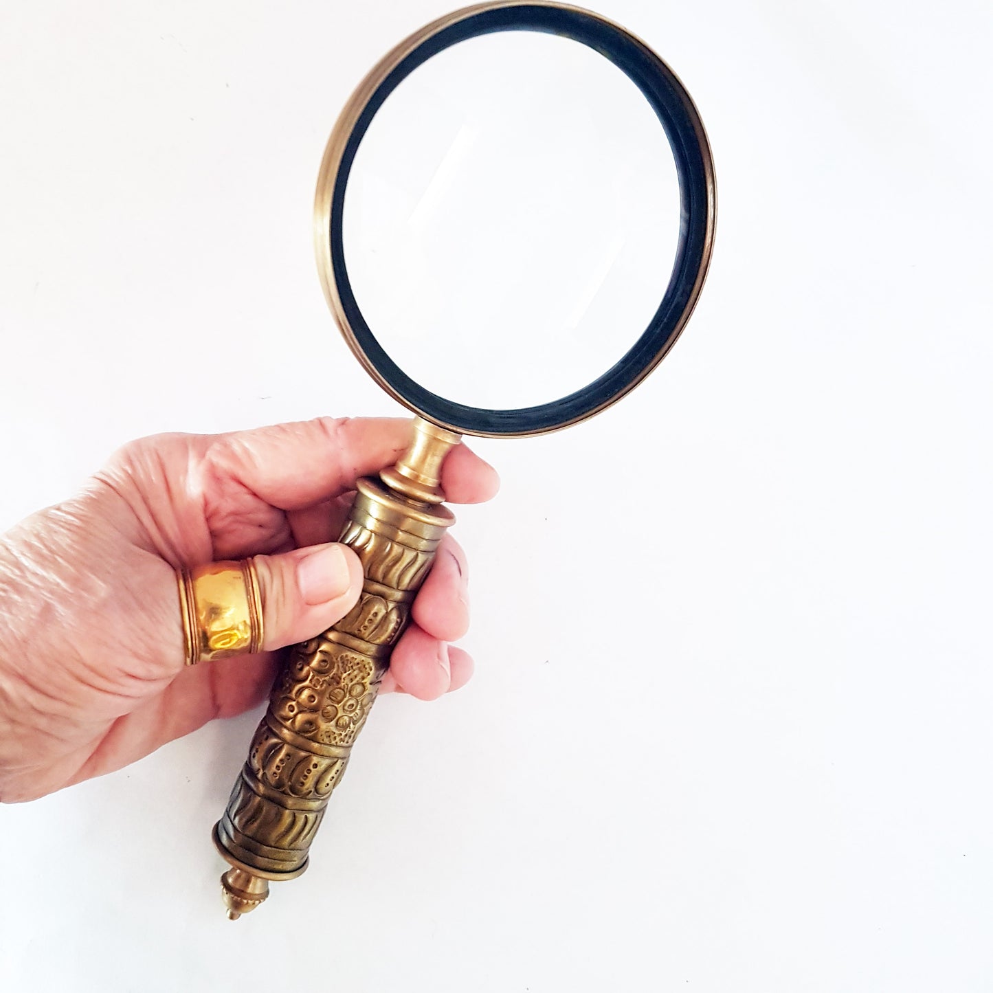 Loupe de style vintage avec une poignée en laiton repoussé d'aspect médiéval. Charme du vieux monde. Lisez facilement les petits caractères sur les étiquettes des aliments et des médicaments.