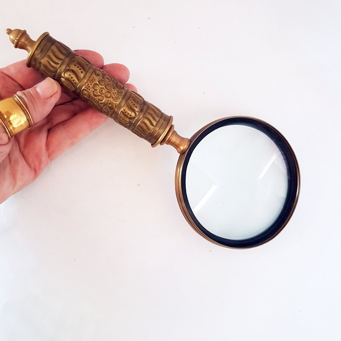 Loupe de style vintage avec une poignée en laiton repoussé d'aspect médiéval. Charme du vieux monde. Lisez facilement les petits caractères sur les étiquettes des aliments et des médicaments.