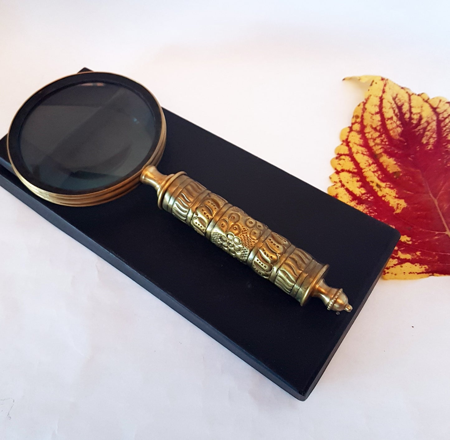 Loupe de style vintage avec une poignée en laiton repoussé d'aspect médiéval. Charme du vieux monde. Lisez facilement les petits caractères sur les étiquettes des aliments et des médicaments.
