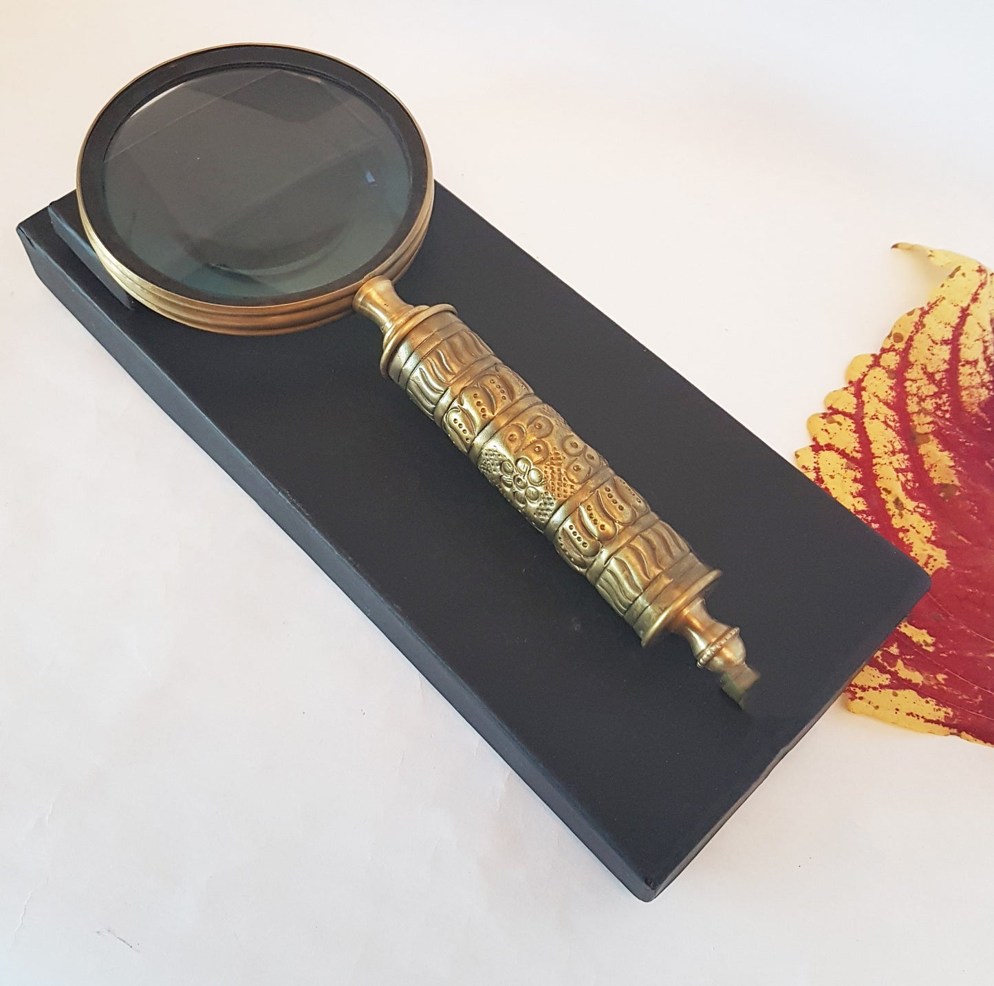 Loupe de style vintage avec une poignée en laiton repoussé d'aspect médiéval. Charme du vieux monde. Lisez facilement les petits caractères sur les étiquettes des aliments et des médicaments.