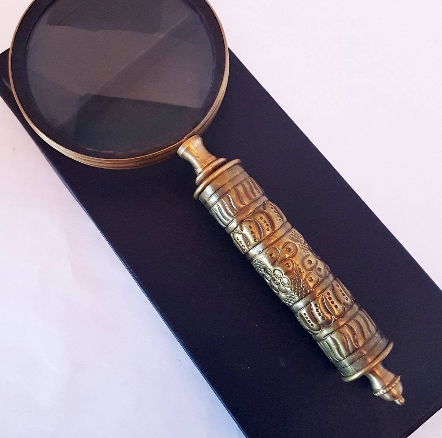 Loupe de style vintage avec une poignée en laiton repoussé d'aspect médiéval. Charme du vieux monde. Lisez facilement les petits caractères sur les étiquettes des aliments et des médicaments.