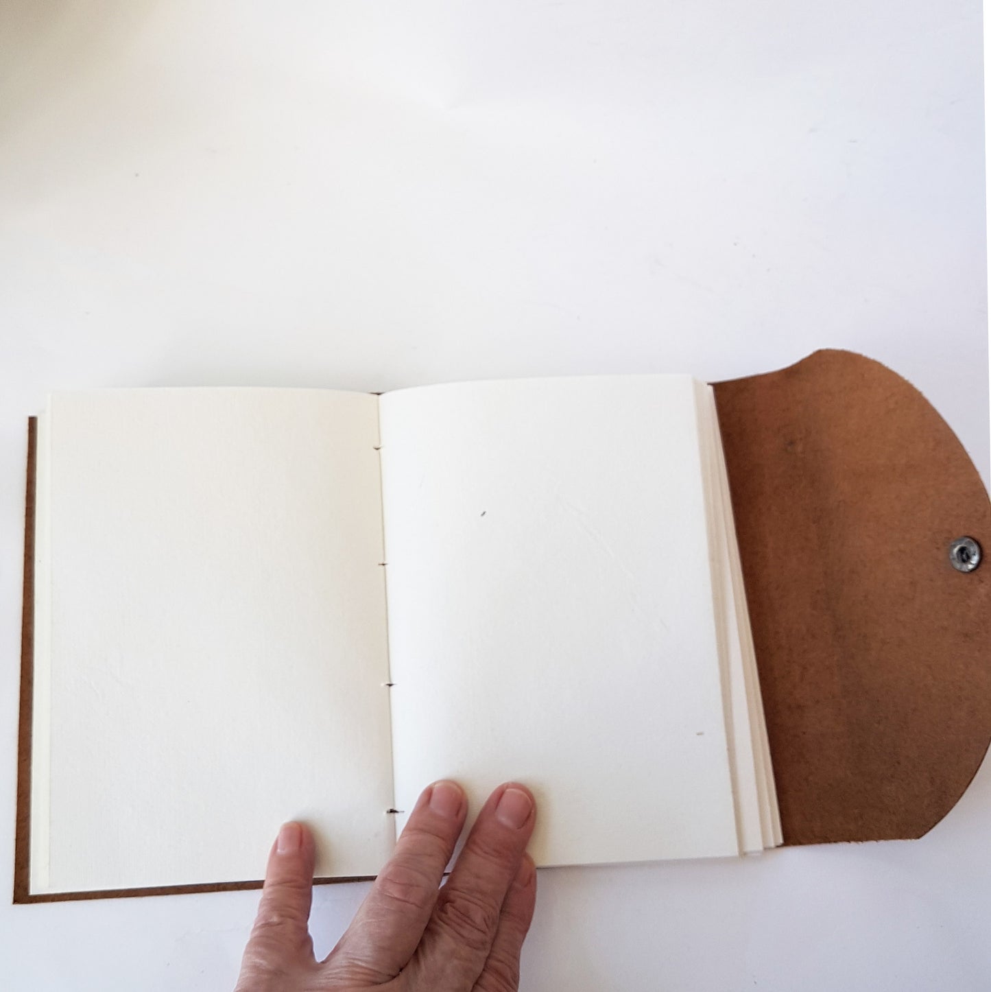 Leather bound brown suede journal with a rustic look. Pewter style button closure. Medieval design aesthetic.