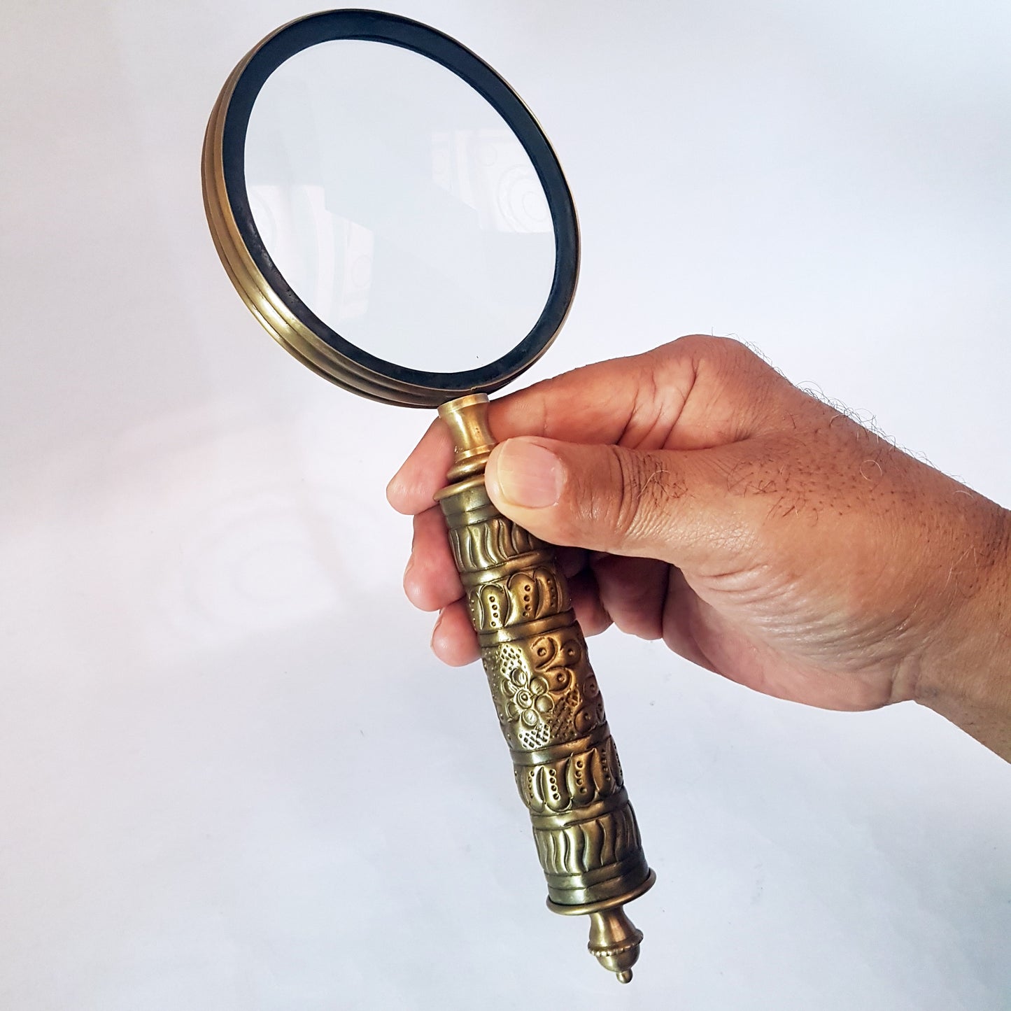 Loupe de style vintage avec une poignée en laiton repoussé d'aspect médiéval. Charme du vieux monde. Lisez facilement les petits caractères sur les étiquettes des aliments et des médicaments.