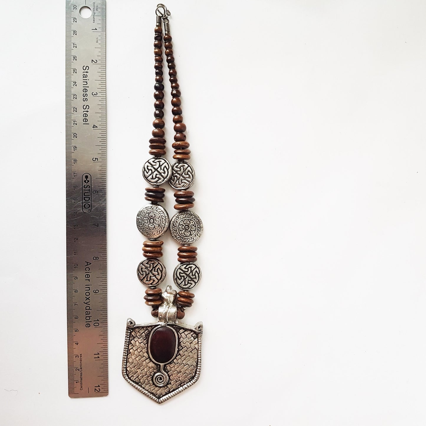 Collier pendentif hexagonal médiéval au design en étain antique. Décoré de disques de symboles d'éternité celtiques en relief et de perles marron foncé.