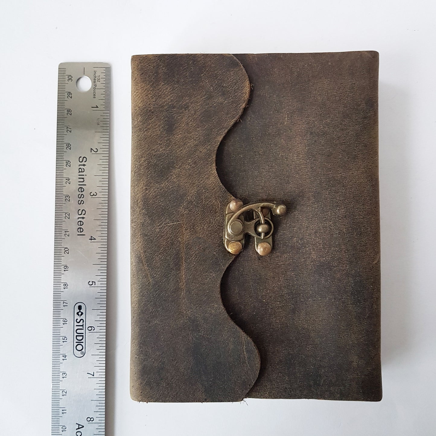 Leather bound suede diary rustic brown journal. Medieval style grimoire with bronze lock. Measures 5 by 7 inches with handmade paper pages.