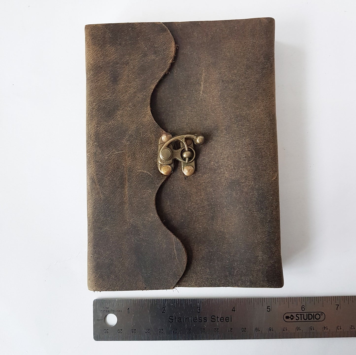 Leather bound suede diary rustic brown journal. Medieval style grimoire with bronze lock. Measures 5 by 7 inches with handmade paper pages.
