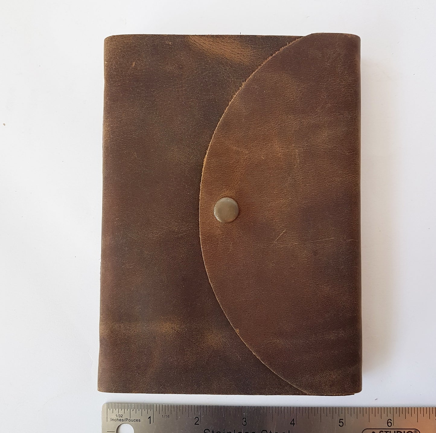 Leather bound brown suede journal with a rustic look. Pewter style button closure. Medieval design aesthetic.