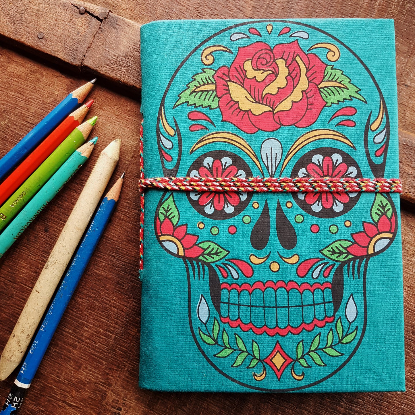 Carnet de croquis en forme de tête de mort bleu sarcelle de 12,7 x 17,8 cm avec des pages vierges en papier artisanal. Journal gothique coloré du jour des morts Sugarskull en bleu sarcelle.