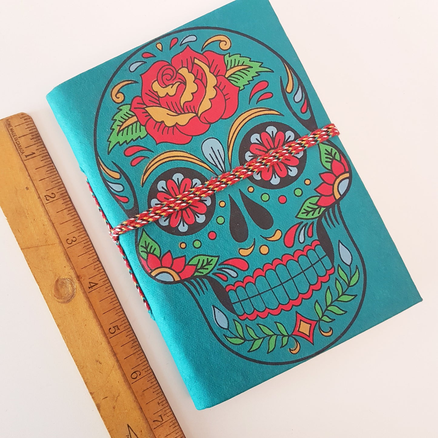 Carnet de croquis en forme de tête de mort bleu sarcelle de 12,7 x 17,8 cm avec des pages vierges en papier artisanal. Journal gothique coloré du jour des morts Sugarskull en bleu sarcelle.