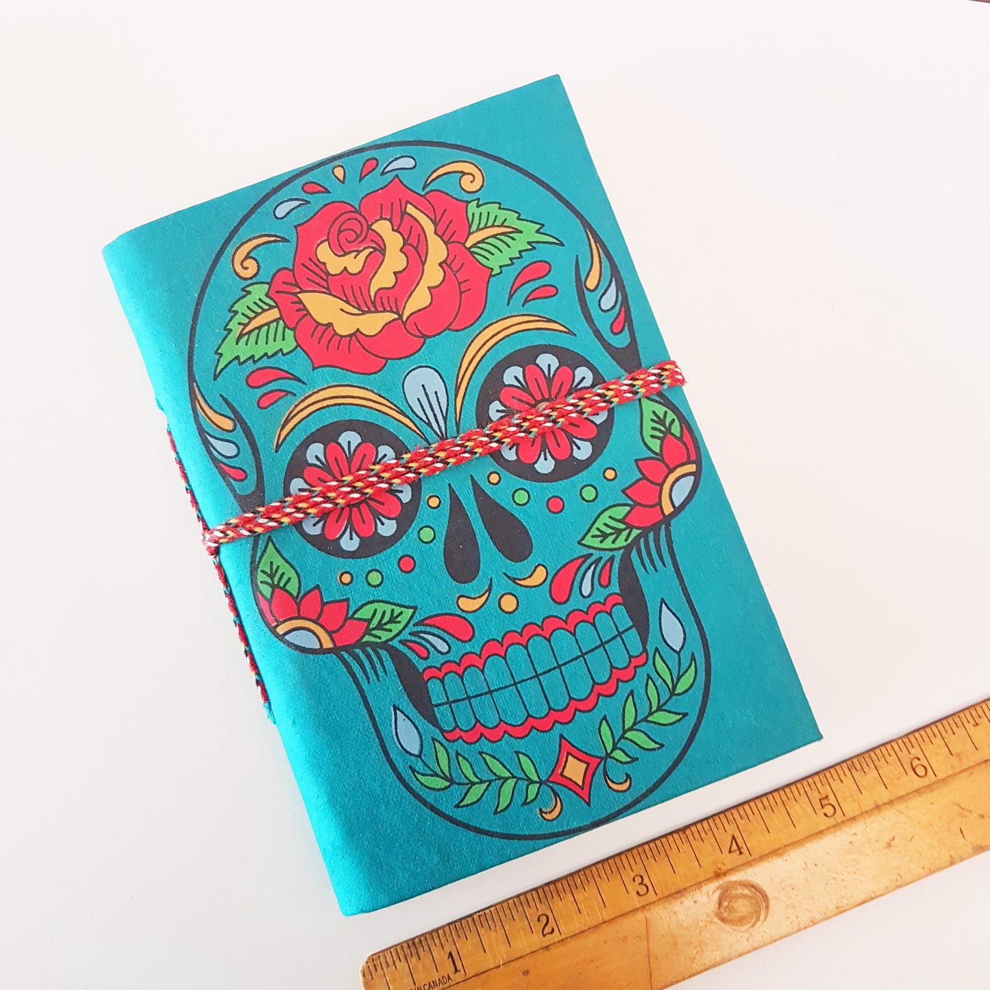 Carnet de croquis en forme de tête de mort bleu sarcelle de 12,7 x 17,8 cm avec des pages vierges en papier artisanal. Journal gothique coloré du jour des morts Sugarskull en bleu sarcelle.