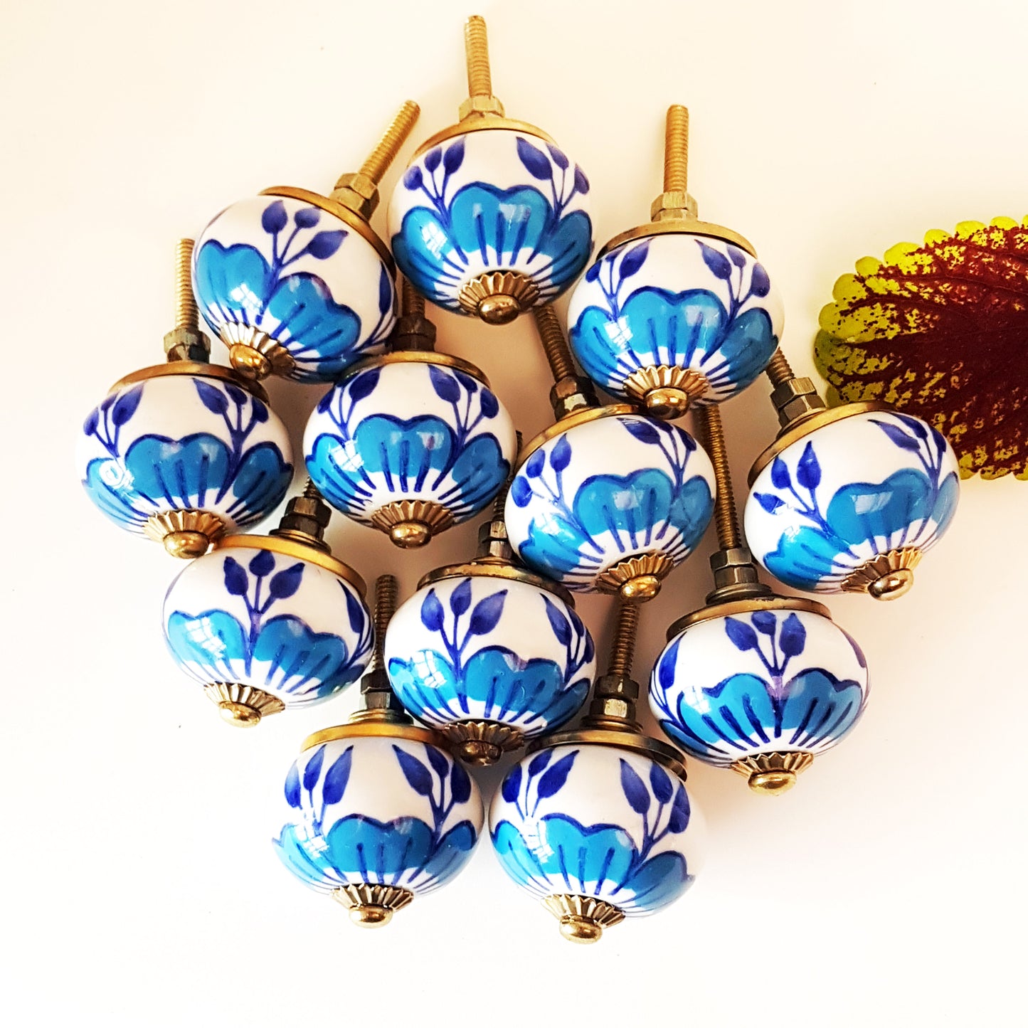 Ensemble de 12 boutons d'armoire à fleurs bleues et blanches avec quincaillerie dorée.