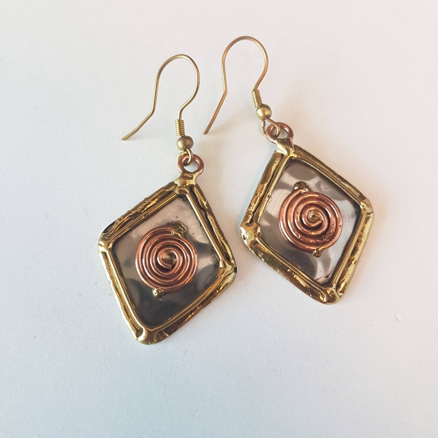 Boucles d'oreilles pendantes en argent avec détails en bronze et cuivre. Forme de diamant en losange celtique.