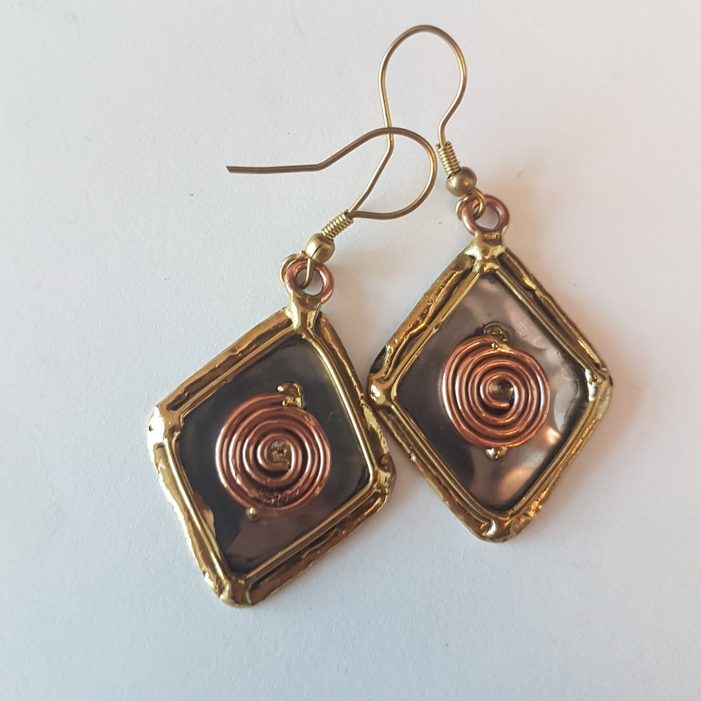 Boucles d'oreilles pendantes en argent avec détails en bronze et cuivre. Forme de diamant en losange celtique.
