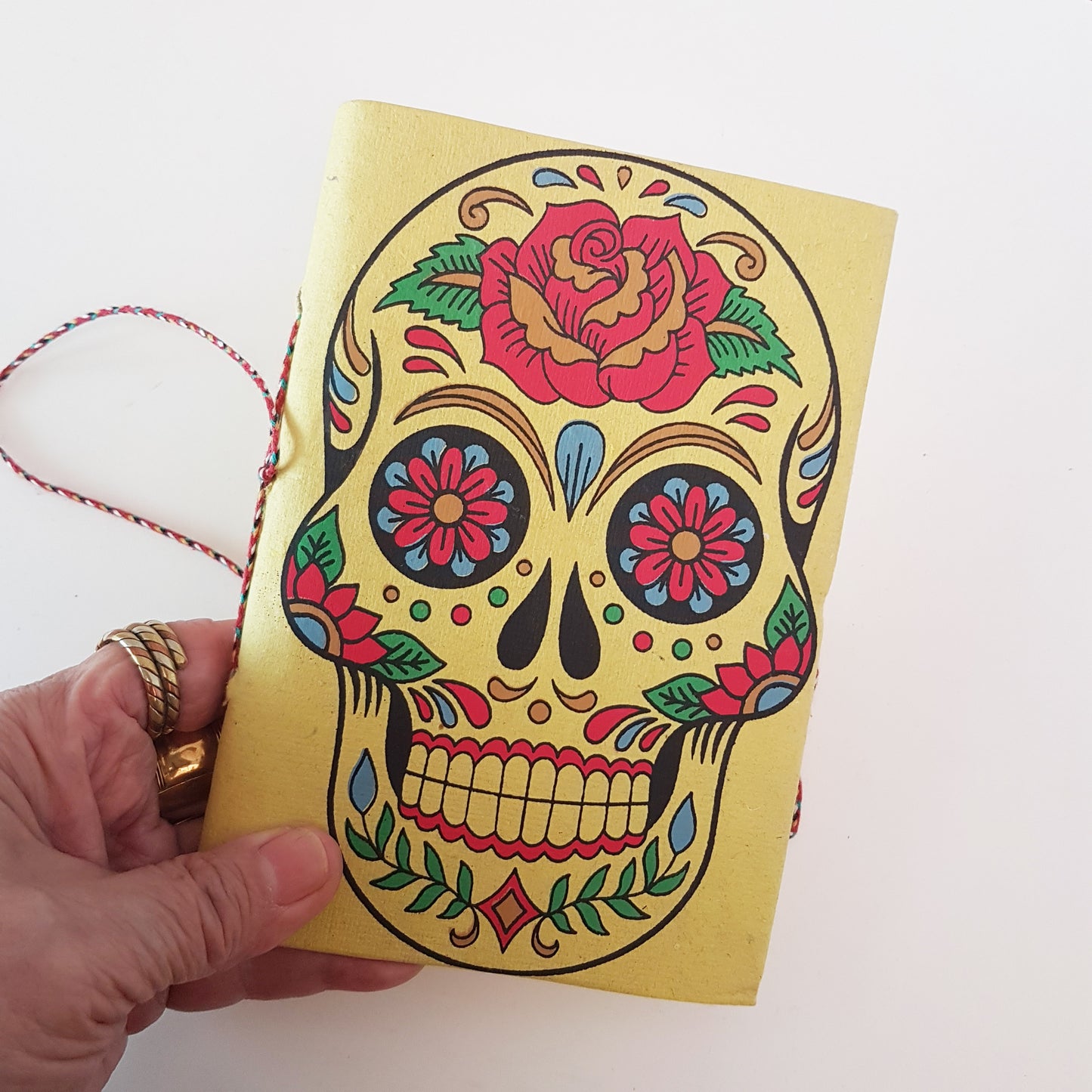 Yellow skull sketchbook jotter 5 by 7 inches with blank artisan paper pages. Colorful lemon gothic day of the dead sugarskull design diary.