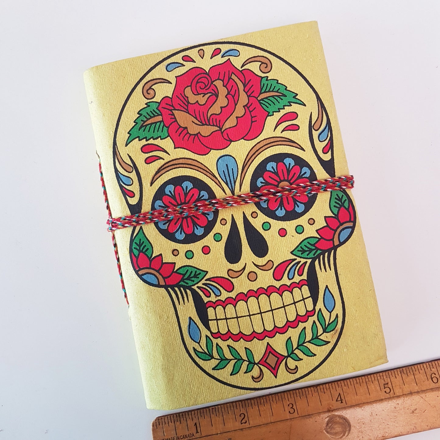 Yellow skull sketchbook jotter 5 by 7 inches with blank artisan paper pages. Colorful lemon gothic day of the dead sugarskull design diary.