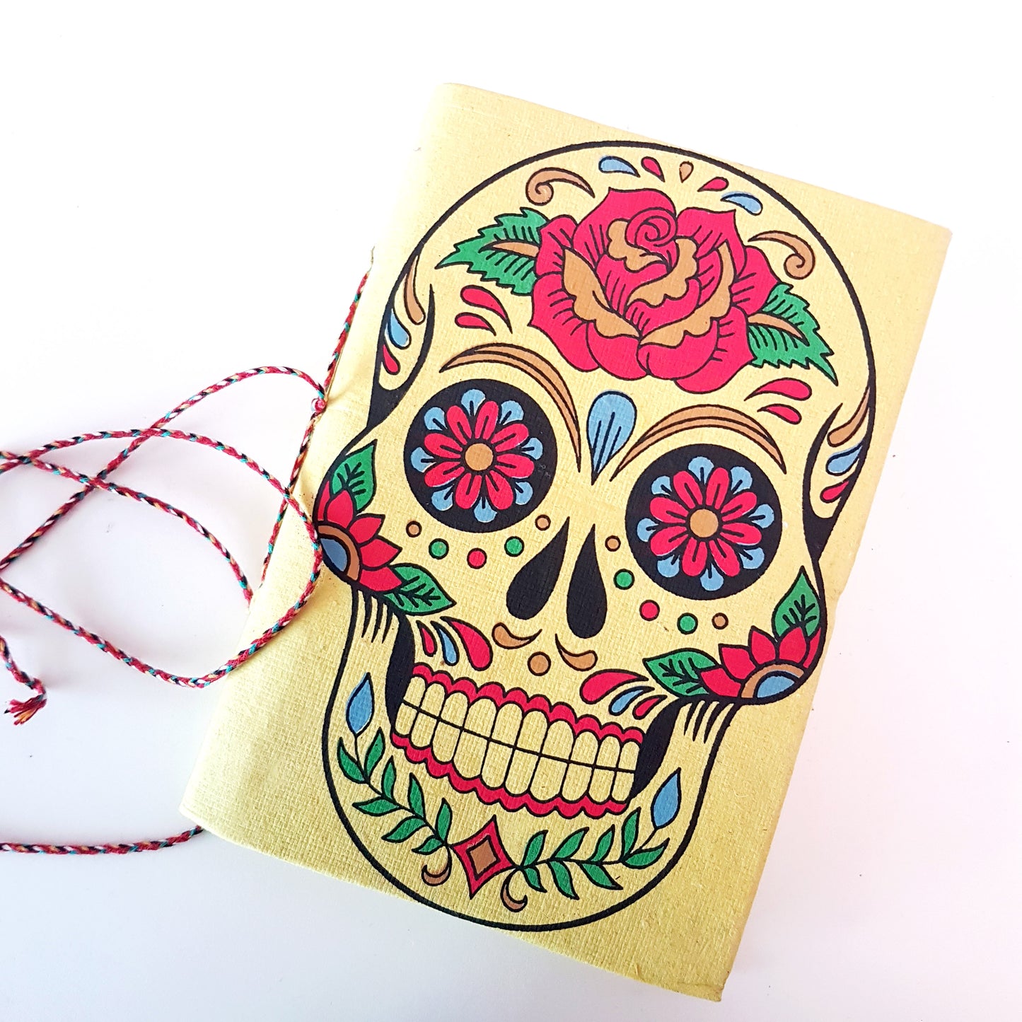Yellow skull sketchbook jotter 5 by 7 inches with blank artisan paper pages. Colorful lemon gothic day of the dead sugarskull design diary.