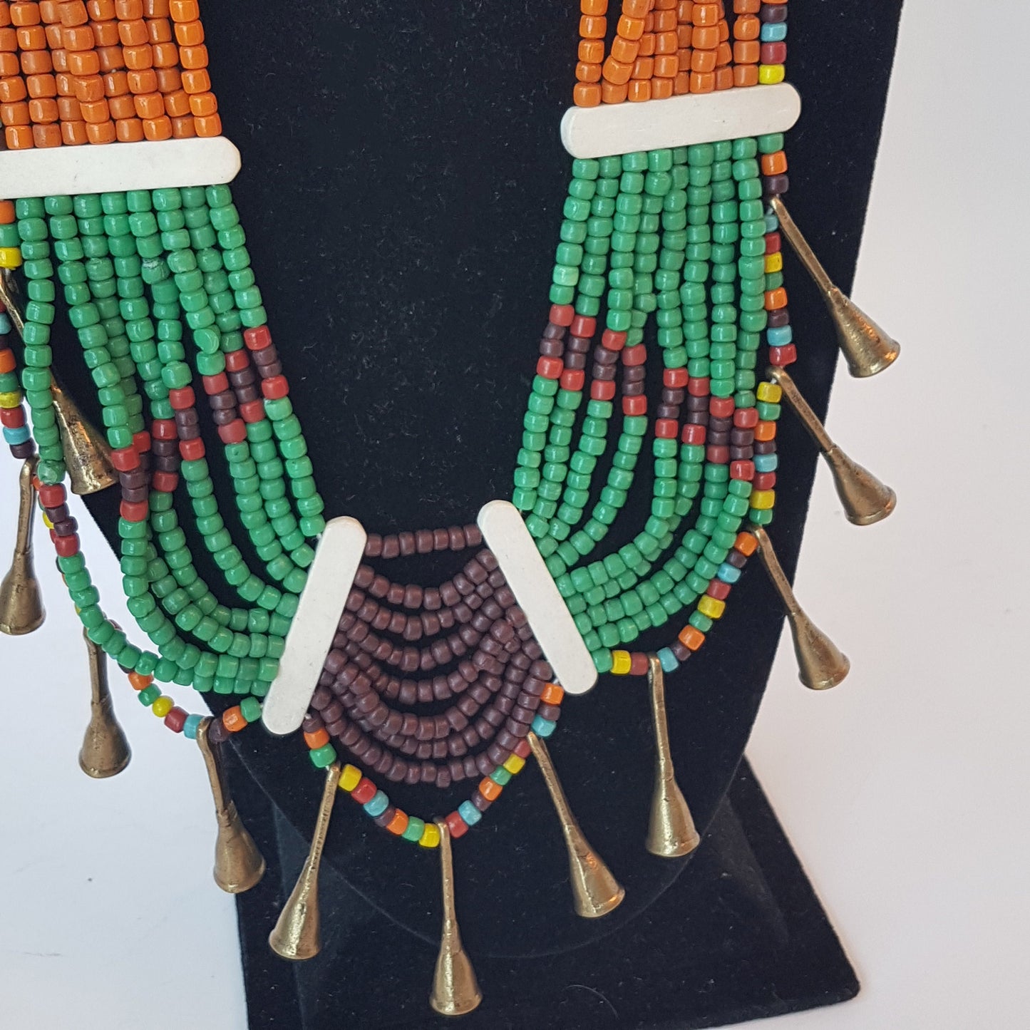 Tribal beaded necklace in a stunning combination of orange, maroon, green and rust. Bone button closing. Antique bronze metal horn detail. - Vintage India Ca