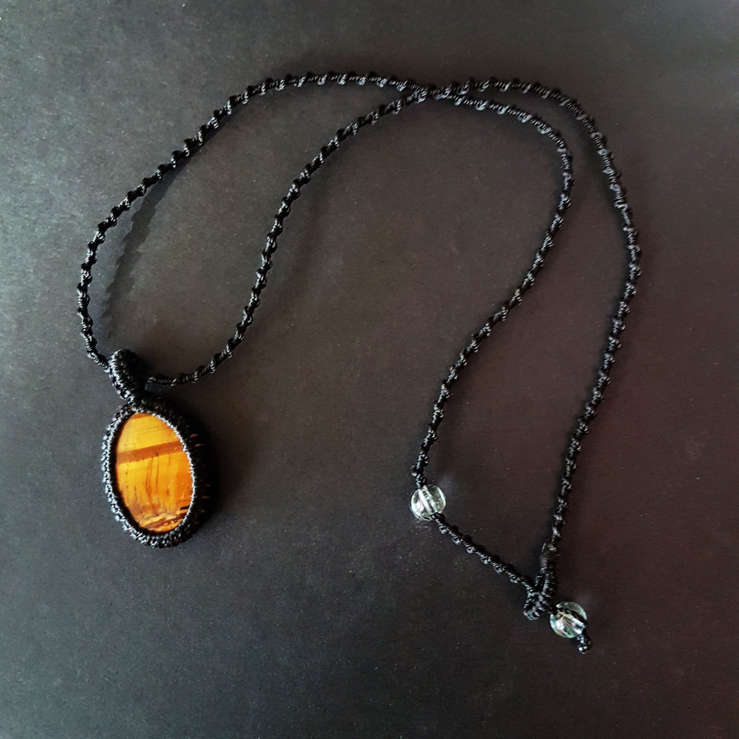 Gender neutral design tigereye pendant necklace. Hangs on a 20 inch black woven corkscrew knot cord. Adjustable length. Unisex jewelry. - Vintage India Ca