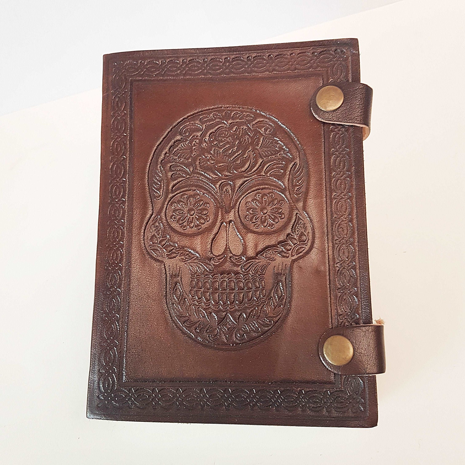 Brown leather embossed skull journal 5 by 7 inches. Exclusive double snap tab closure system.