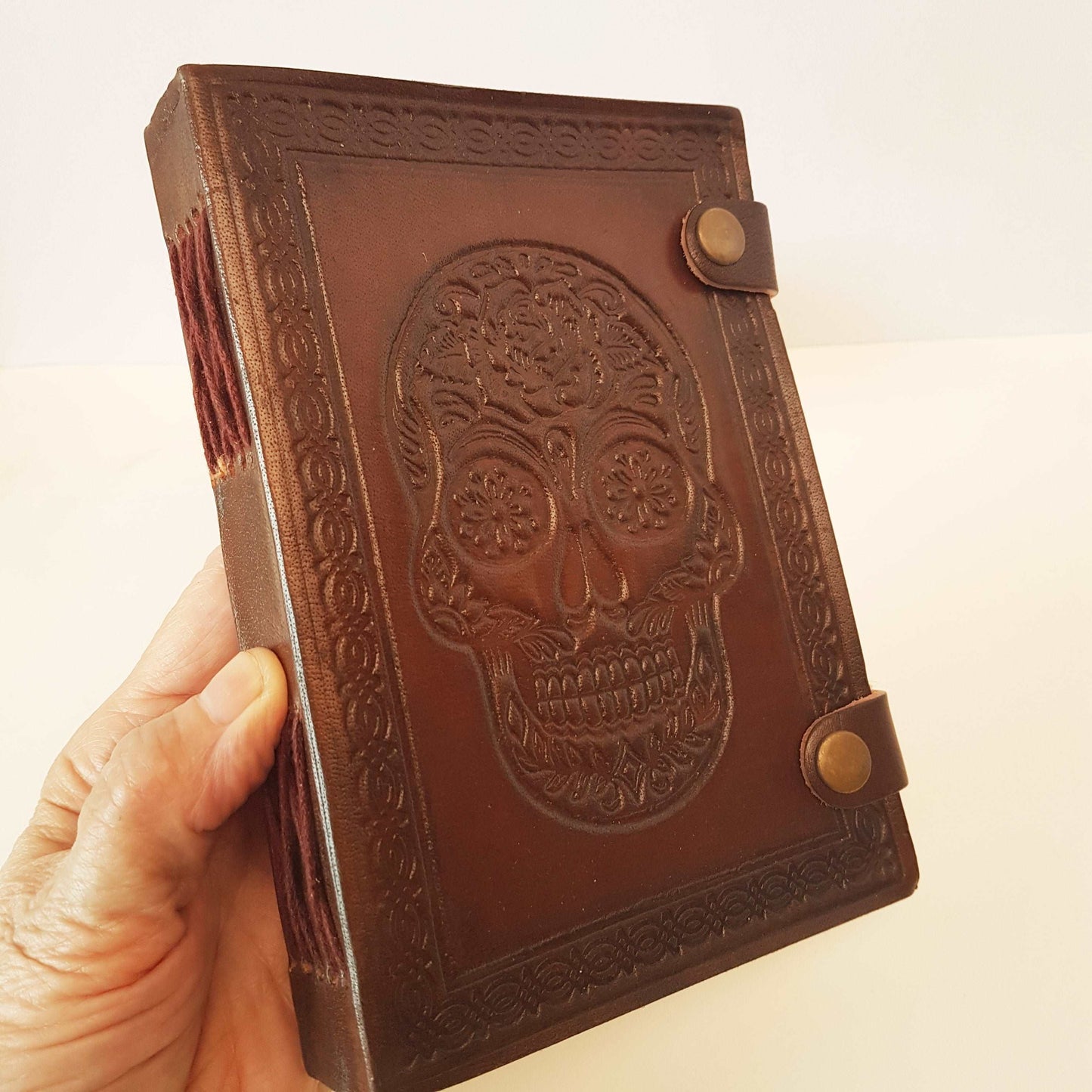 Brown leather embossed skull journal 5 by 7 inches. Exclusive double snap tab closure system.