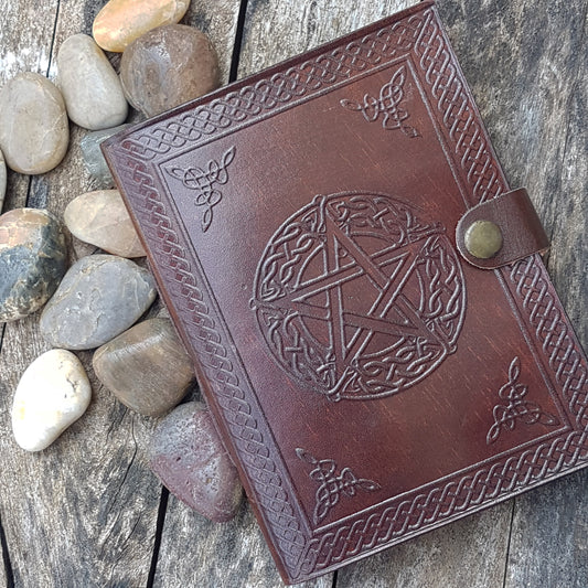 Leather bound journal with an embossed pentagram cover design.