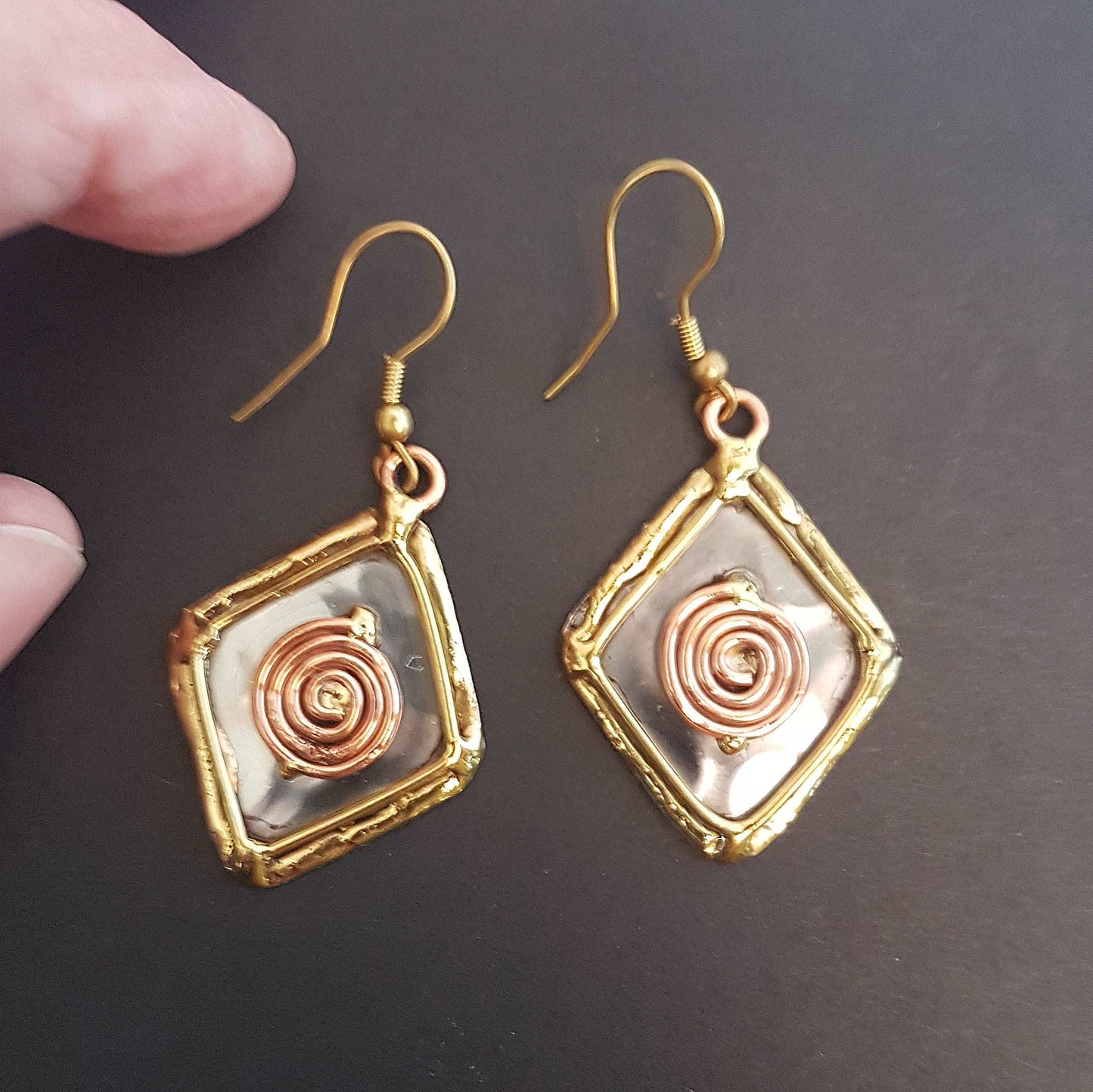 Celtic silver earrings in a diamond shape with gold and copper tone wirework detail.