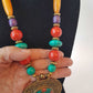 Bohemian designer necklace with turquoise & copal beads. Vintage design embossed bronze metal pendant. Impressive colorful piece.