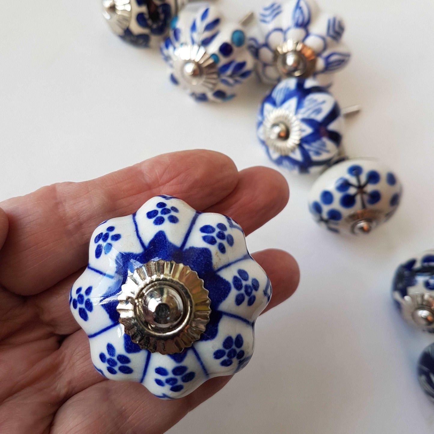 Ceramic cupboard-drawer knobs-pulls set of 8. Blue and white, unique hand painted floral designs. One and a half inch diameter.