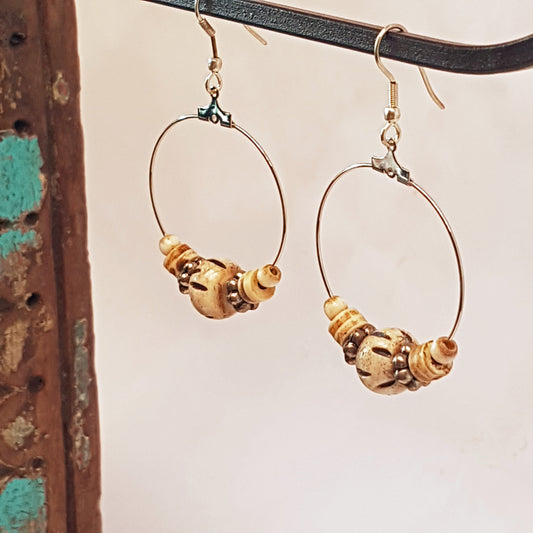 Silver hoop earrings with silver & carved bone beads. 2.5 inches hang length.