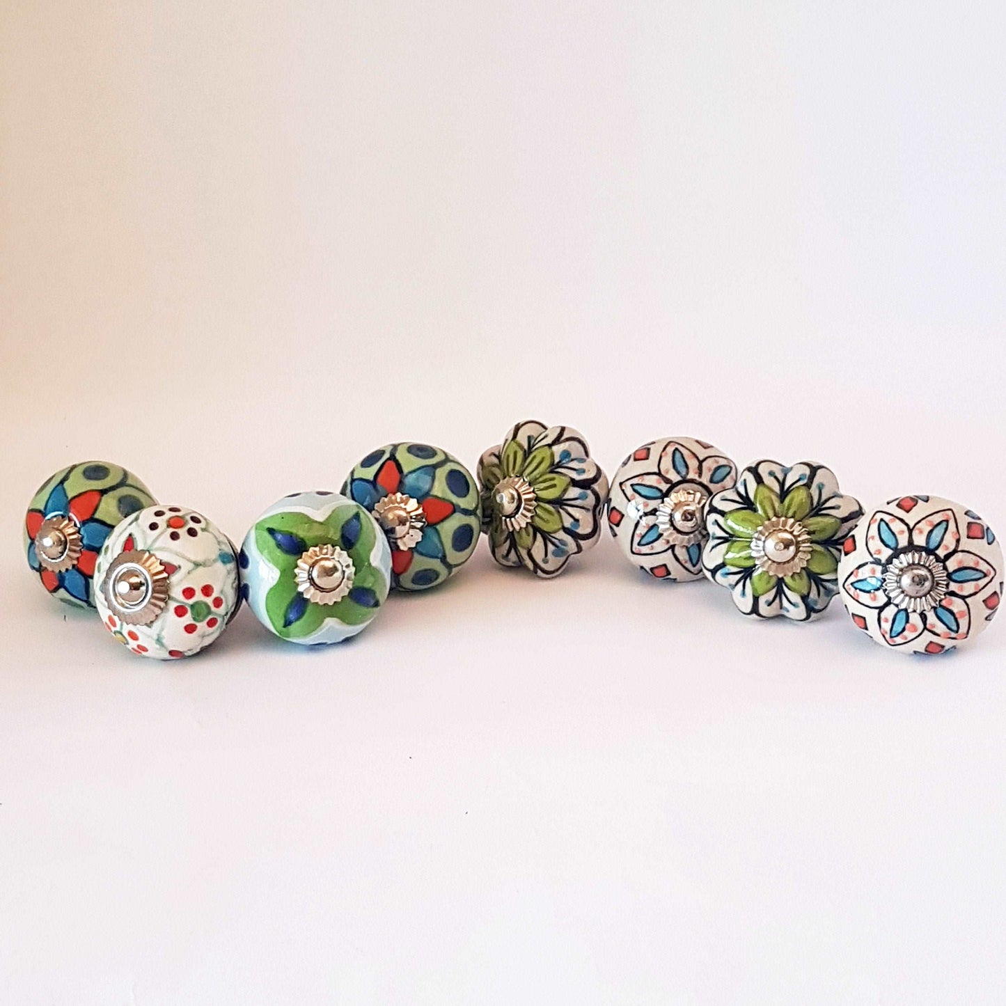 8 hand painted drawer pull cupboard knobs. Exclusive hand painted 8 piece set in blue, green & white floral patterns with silver centers.