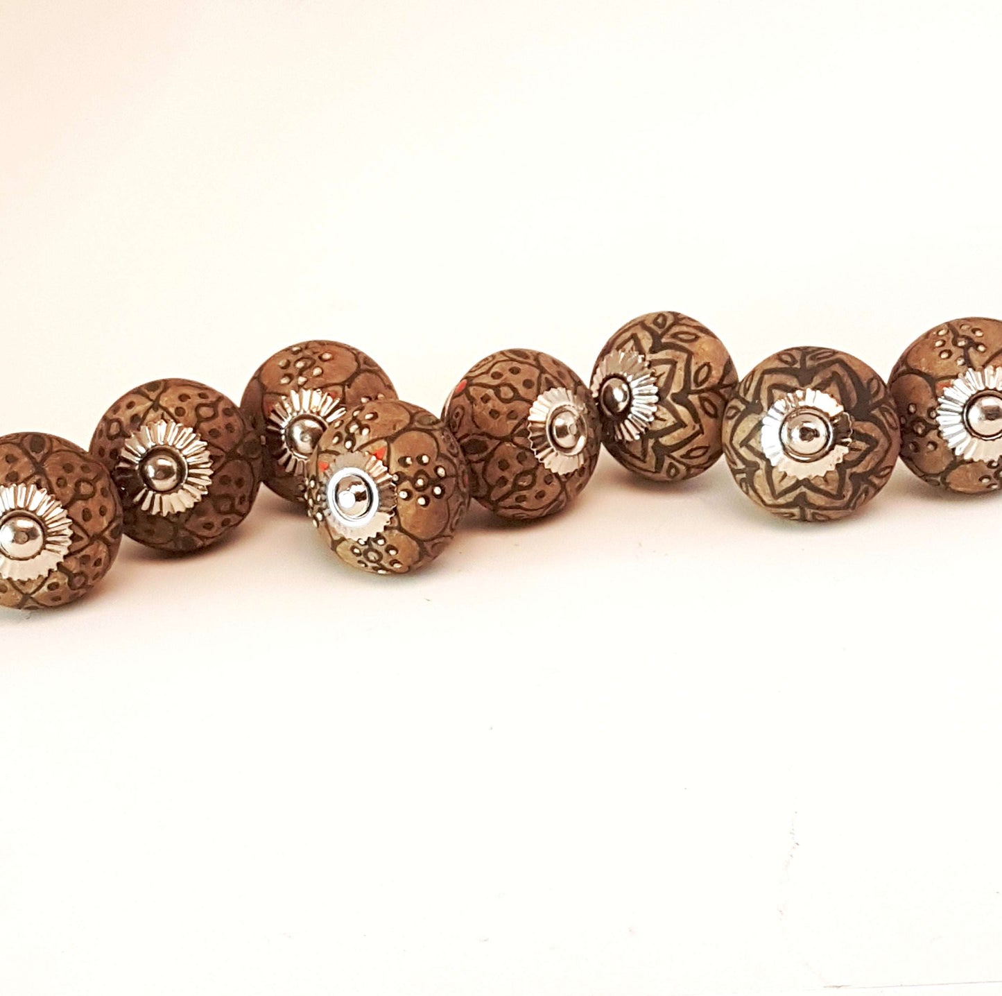 8 cabinet knobs hand painted in rustic country designs. Black & brown floral patterns with silver hardware. Easy and affordable DIY decor.