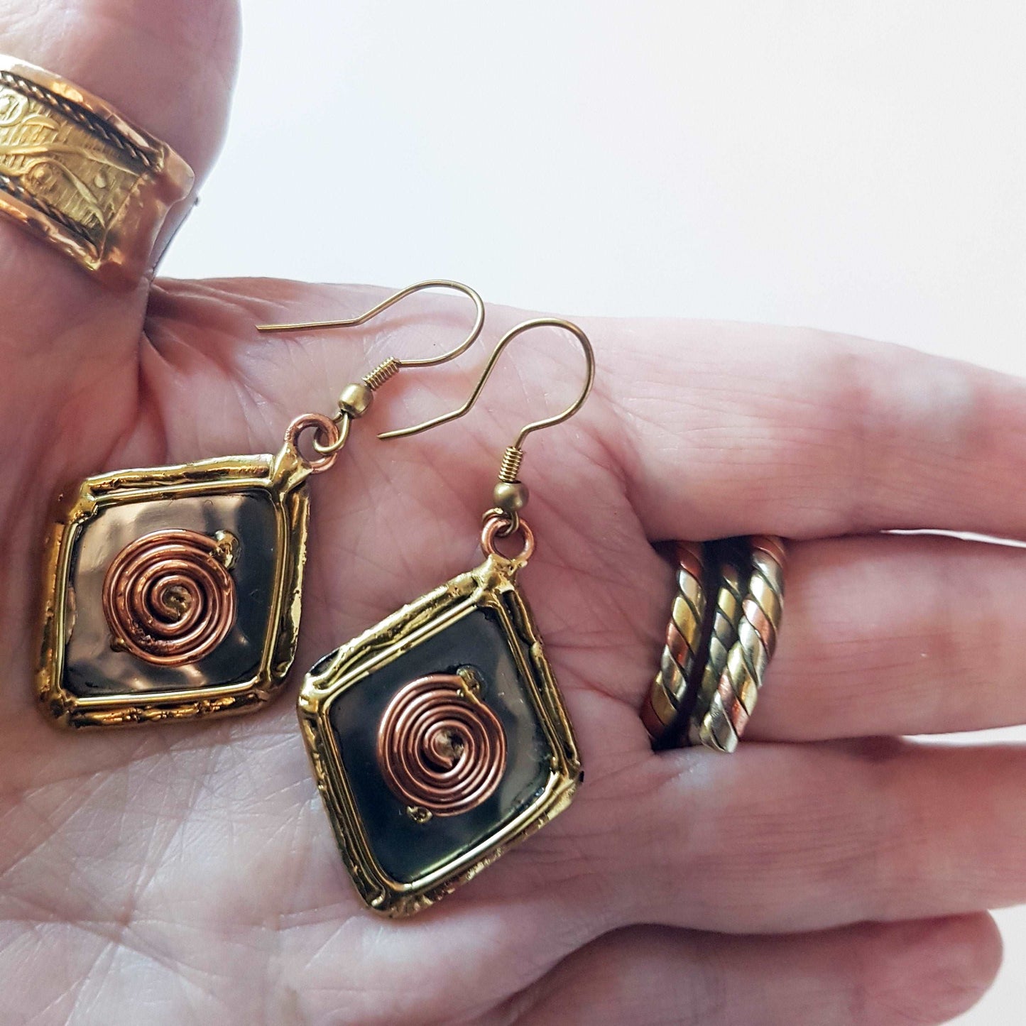 Celtic silver earrings in a diamond shape with gold and copper tone wirework detail.