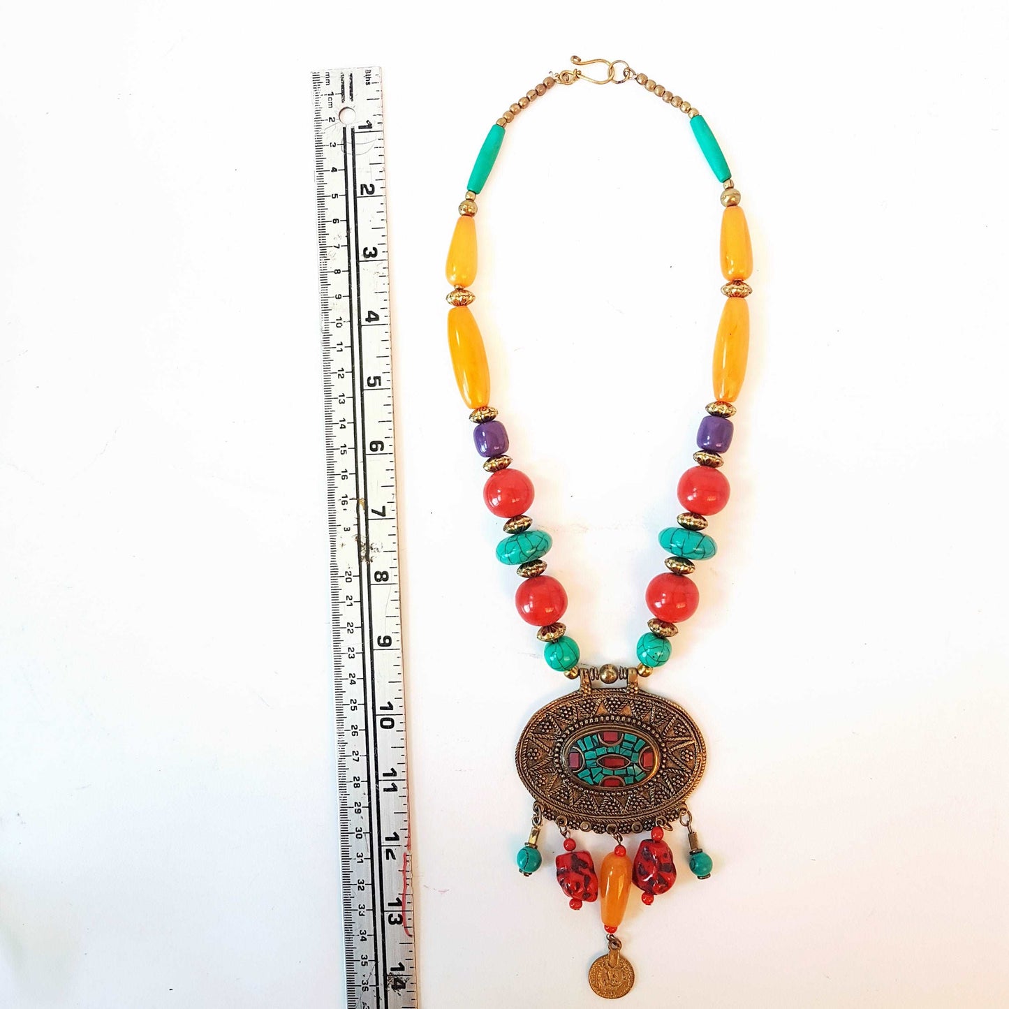 Bohemian designer necklace with turquoise & copal beads. Vintage design embossed bronze metal pendant. Impressive colorful piece.