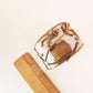 Bracelet manchette en argent avec pierre oeil de tigre de forme rectangle. Ajustement réglable. Conception artisanale en métal mélangé avec des détails en cuivre et en laiton.