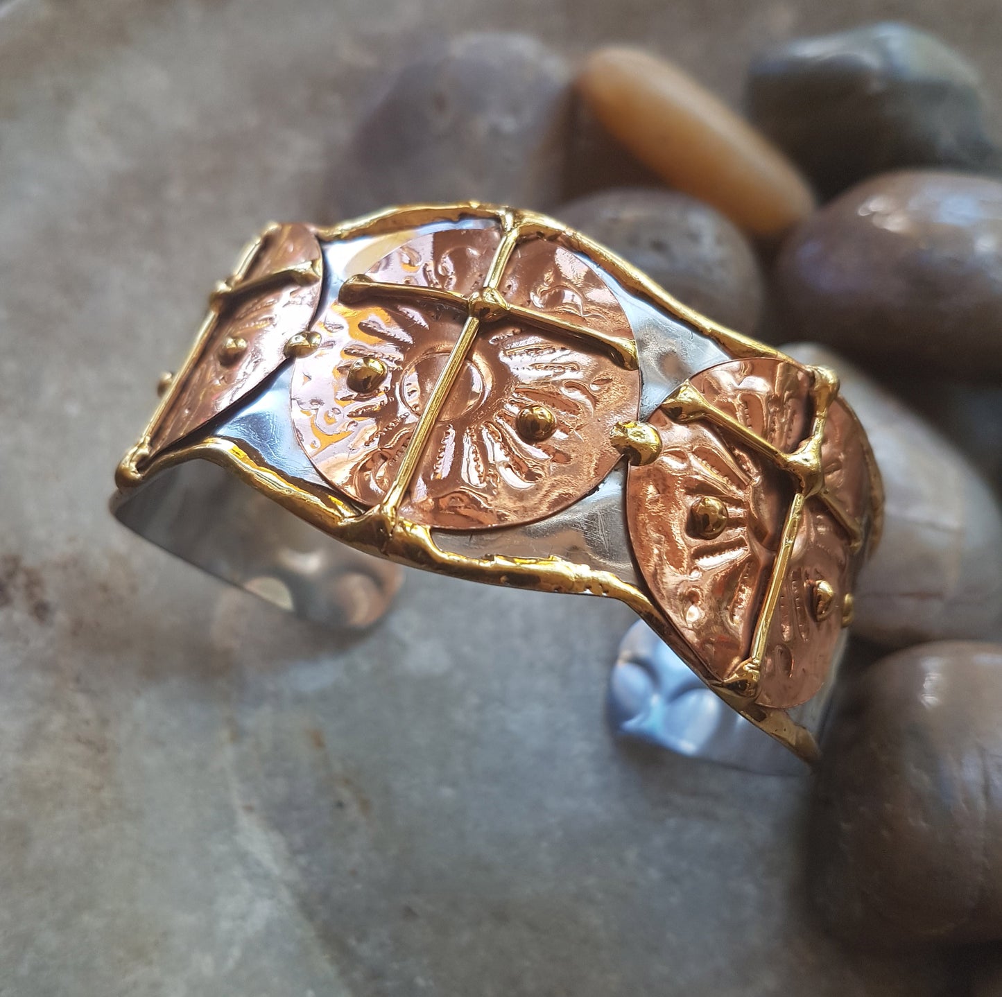 Silver cuff bracelet with a hammered mixed metal design.